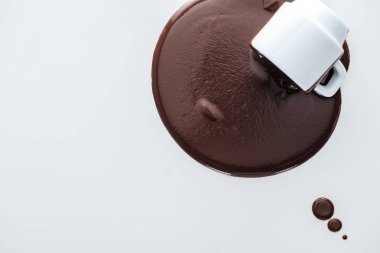 Beyaz arka plan üzerine dökülen çikolata ve çikolata damlaile fincan üst görünümü 