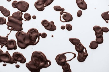 Top view of drops of melted dark chocolate on white background  clipart