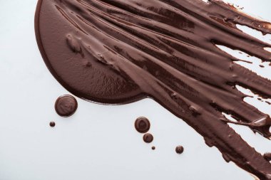 Top view of spilled dark chocolate and chocolate drops on white background clipart