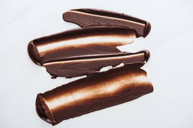 Top view of dark chocolate brushstrokes on white background clipart