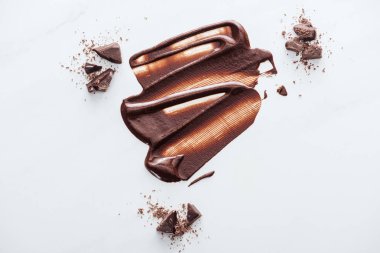 Top view of liquid chocolate with pieces of chocolate and cocoa powder clipart