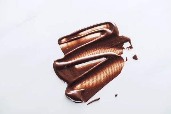 白い背景に液体ダークチョコレートのトップビュー — ストック写真