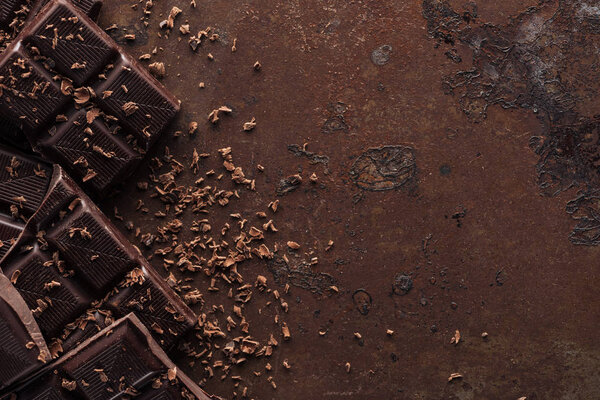 Pieces of chocolate bar with chocolate chips on metal background