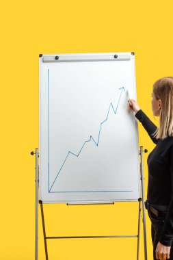 beyaz flipchart yanında duran iş kadını, büyüme grafik işaret, sarı izole ayakta