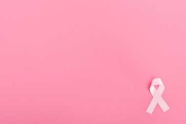 top view of pink ribbon on pink background with copy space, breast cancer concept clipart