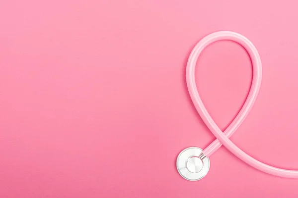 粉红色听诊器在粉红色背景与复制空间的顶部视图 — 图库照片