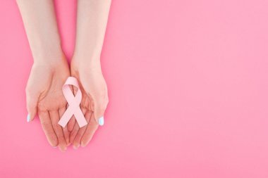 partial view of woman with pink breast cancer sign on pink background with copy space clipart