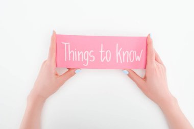 cropped view of woman holding pink card with things to know lettering on white background clipart