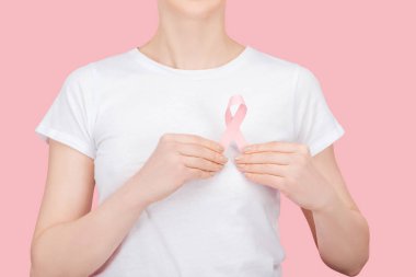 partial view of woman in white t-shirt holding pink breast cancer sign isolated on pink clipart