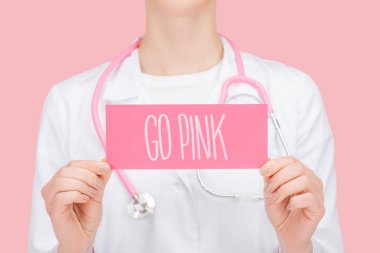 beyaz ceket ve stetoskop tutan kart pembe izole pembe yazı ile doktor kısmi görünümü