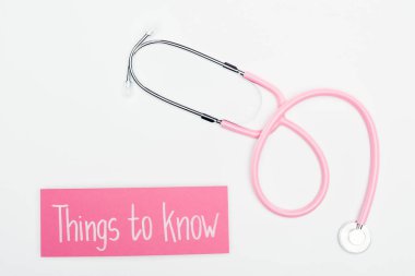 top view of stethoscope and pink card with things to know lettering on white background clipart
