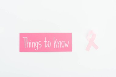 top view of breast cancer sign and pink card with things to know on white background clipart