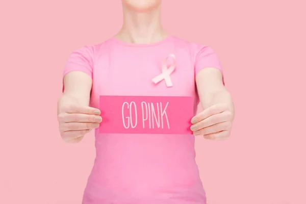 ピンクのTシャツを着た女性のトリミングされたビューは ピンクで孤立したシルク乳がんの歌で指で指を指さす — ストック写真