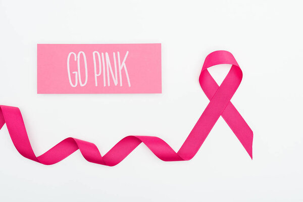 top view of curved crimson breast cancer ribbon and card with go pink lettering on white background