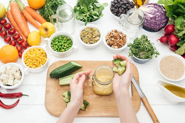 Cropped View Woman Adding Chopped Cucumber Couscous Glass Jar Wooden — Stock Photo, Image