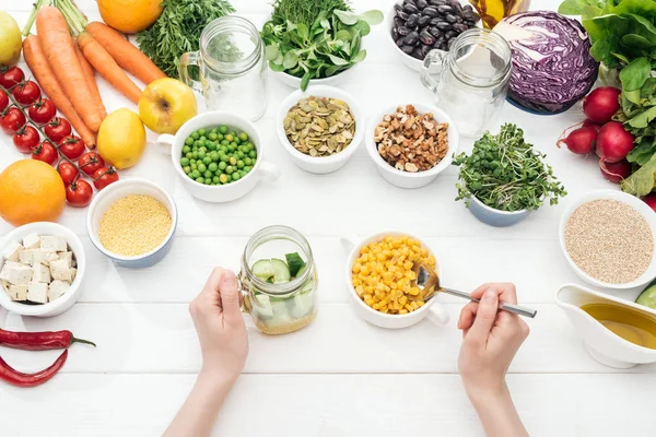 Cropped View Woman Adding Corn Jar Cucumbers Wooden White Table — Stock Photo, Image