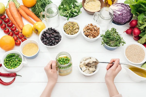 Cropped View Woman Adding Tofu Cheese Jar Salad Wooden White — Stock Photo, Image