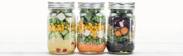 stock image delicious vegetable salad in jars on wooden white table isolated on white, panoramic shot