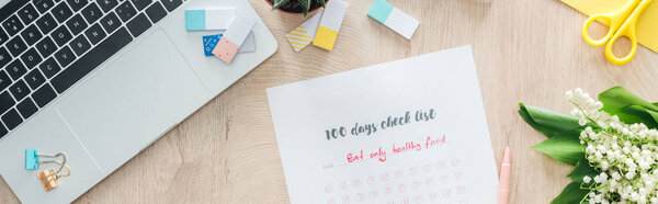 panoramic view of 100 days challenge list, stationery and laptop on wooden table