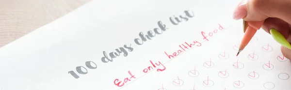 100日のチェックリストでメモを書く女性のトリミングビュー 手に赤いペンを持って — ストック写真