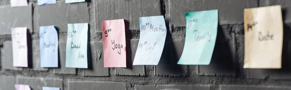 селективный фокус цветных наклеек с нотами на черной кирпичной стене
