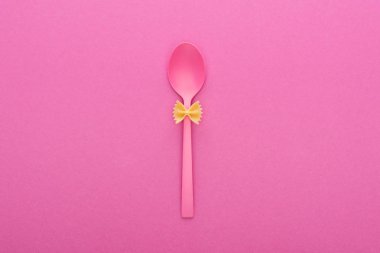pembe izole plastik kaşık üzerinde pişmemiş farfalle makarna