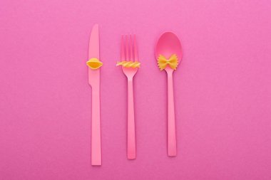 pembe plastik çatal üzerinde makarna farklı türde üst görünümü pembe izole