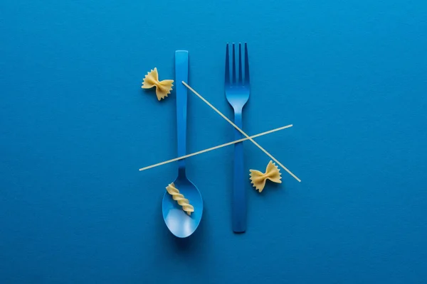 Top View Spaghetti Blue Plastic Spoon Upside Fork Two Kinds — Stock Photo, Image