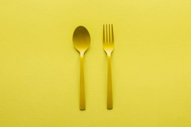 sarı üzerinde izole sarı kaşık ve çatal üst görünümü