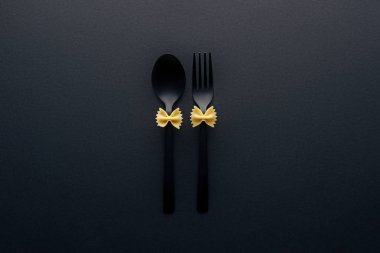 plastik kaşık ve çatal siyah izole üzerinde pişmemiş farfalle makarna