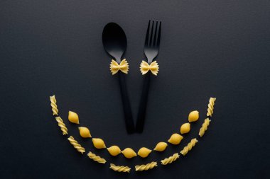 plastik kaşık ve kabukları makarna ve rotini makarna siyah izole yakın çatal üzerinde pişmemiş farfalle makarna