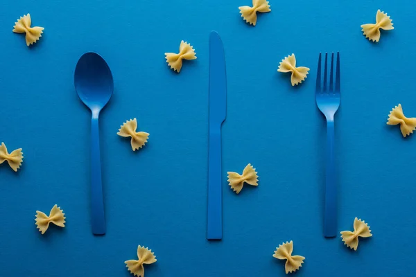 Talheres Plástico Azul Com Macarrão Farfalle Não Cozido Torno Fundo — Fotografia de Stock