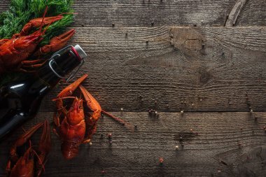 top view of red lobsters, dill and bottle with beer on wooden surface clipart