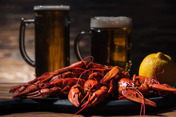 Selective focus of red lobsters, lemon and glasses with beer on wooden surface — Stock Image Selective Focus Red Lobsters Lemon Glasses Beer Wooden Surface Stock Image