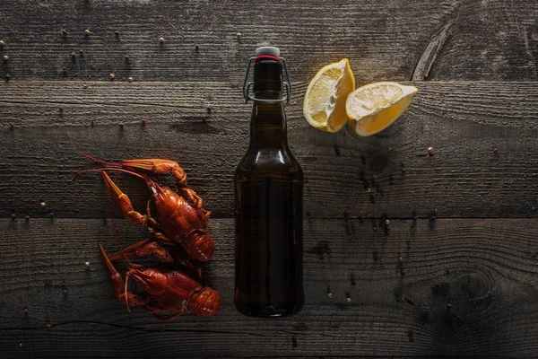 Top view of red lobsters, lemon slices and bottle with beer on wooden surface — Stock Image Top View Red Lobsters Lemon Slices Bottle Beer Wooden Surface Stock Image
