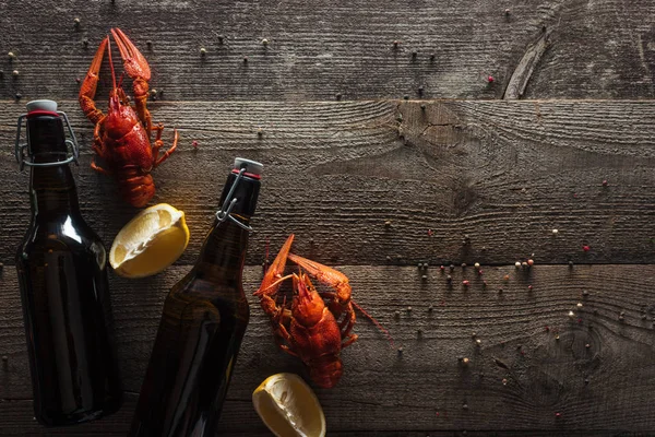 Top view of red lobsters, lemon slices and bottles with beer on wooden surface — Stock Image Top View Red Lobsters Lemon Slices Bottles Beer Wooden Surface Stock Photo