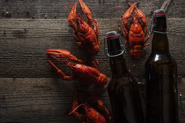 Top view of red lobsters and bottles with beer on wooden surface — Stock Image Top View Red Lobsters Bottles Beer Wooden Surface Stock Image