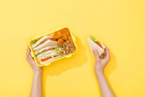 午餐盒的裁剪视图与坚果 干杏和三明治在妇女手中 — 图库照片