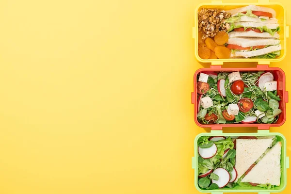 Draufsicht Auf Drei Lunchboxen Mit Lebensmitteln Auf Gelbem Hintergrund — Stockfoto