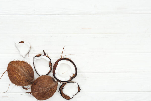 top view of coconuts on white wooden surface