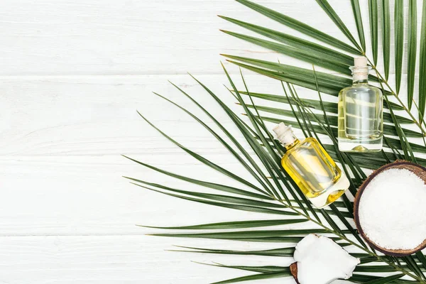 Top View Coconut Oil Bottles Green Palm Leaves White Wooden — Stock Photo, Image