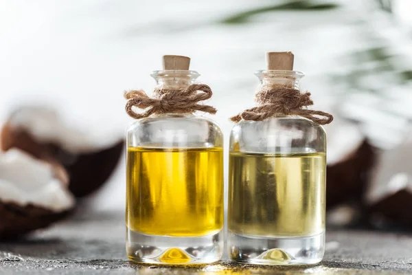 Selective Focus Bottles Coconut Oil Grey Textured Surface — Stock Photo, Image