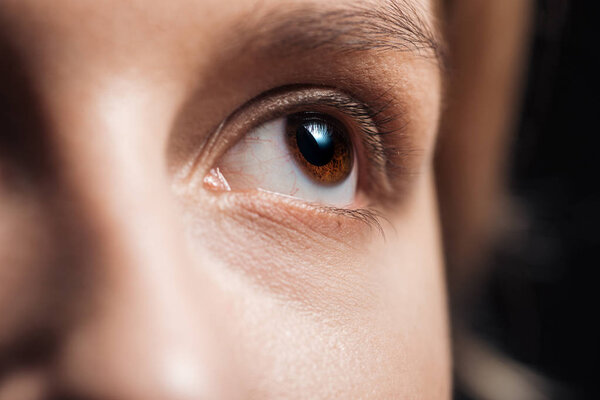 close up view of young woman brown eye looking away