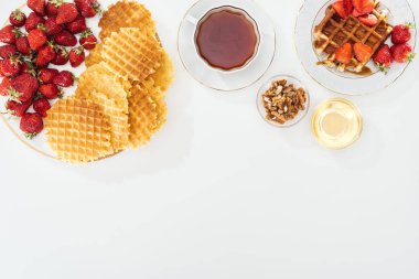 beyaz waffle, çilek, bal, fındık ve çay üst görünümü