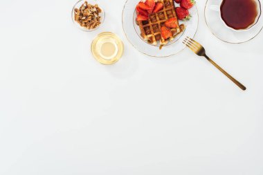 çay ve beyaz waffle ile plaka yakın fındık ve bal ile kase üst görünümü