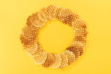 top view of tasty waffles in circle with emptiness in middlr on yellow clipart