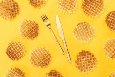 ortasında çatal bıçak takımı ile waffle üst görünümü sarı izole