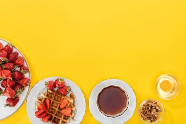 sarı fındık ve bal ile çay ve kase fincan ile çilek ve waffle ile tabak üst görünümü