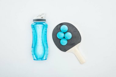 top view of blue sport bottle near ping pong balls and rackets isolated on white  clipart