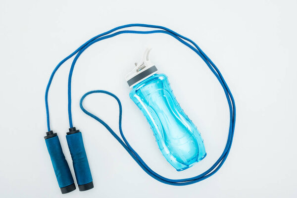 top view of sport bottle near skipping rope isolated on white 
